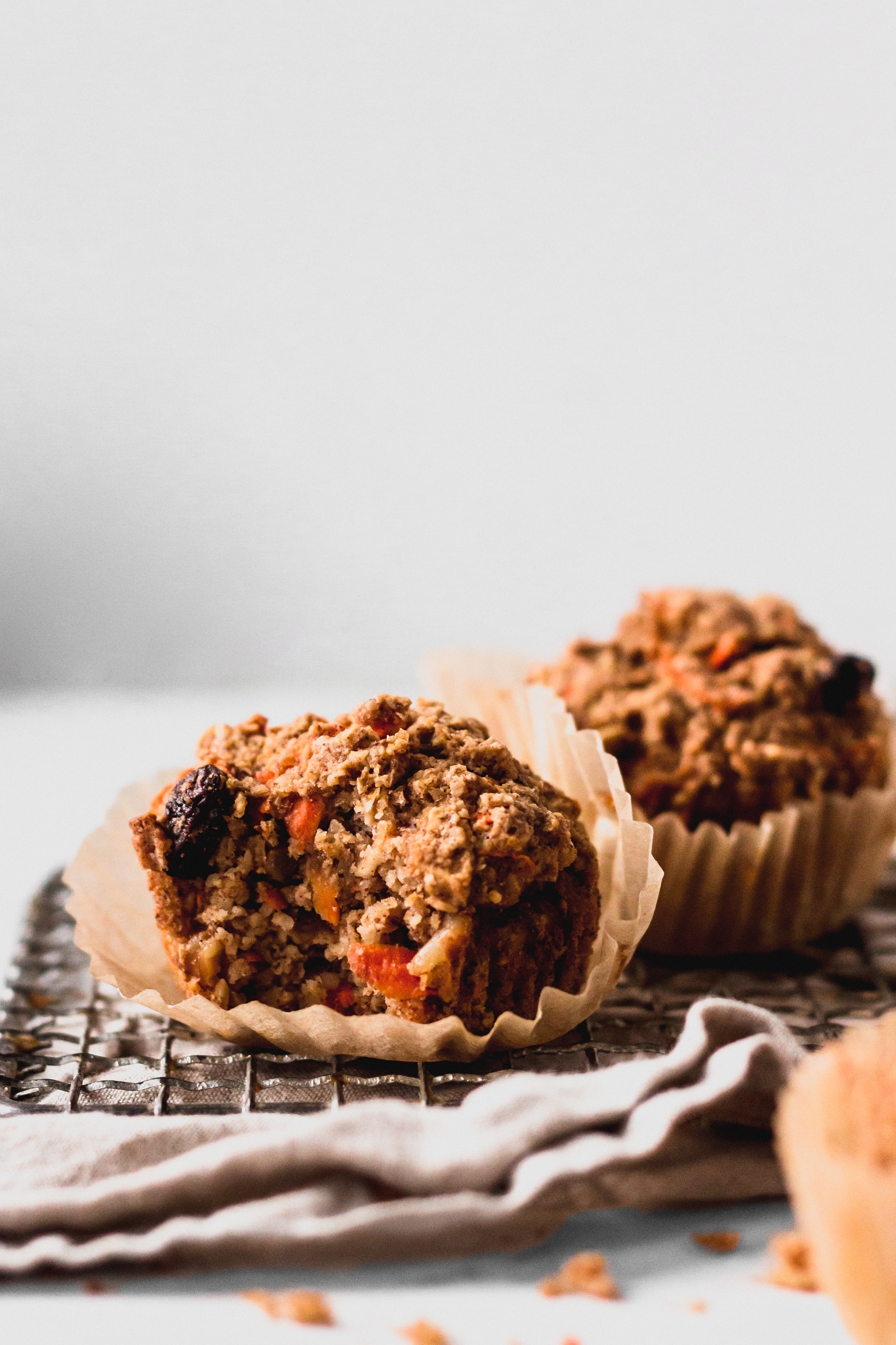 a vegan carrot cake muffin with a bite taken out of it