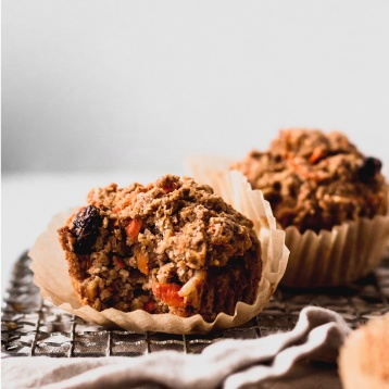a close up shot of a carrot muffin with a bite taken from it