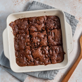 a pan of chocolate chip almond butter bars cut into nine pieces