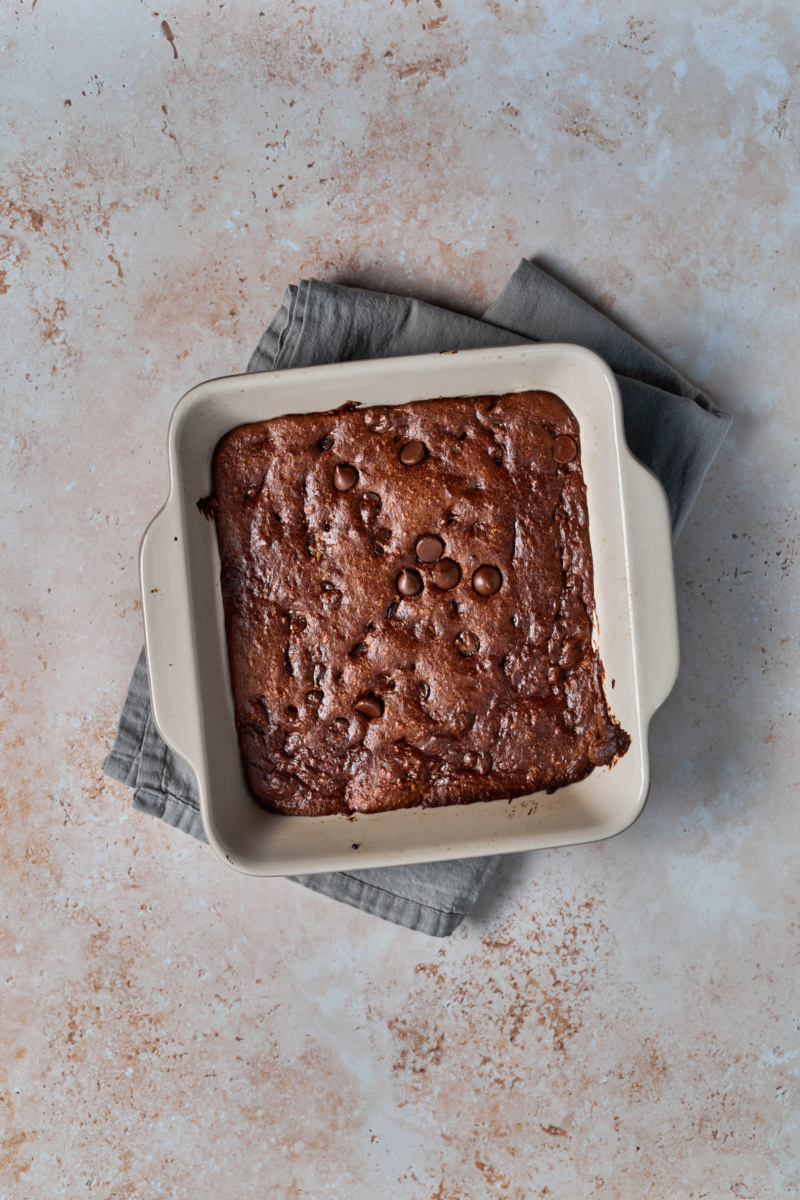 a tray of almond butter chocolate chip blondies resting on a dish towel