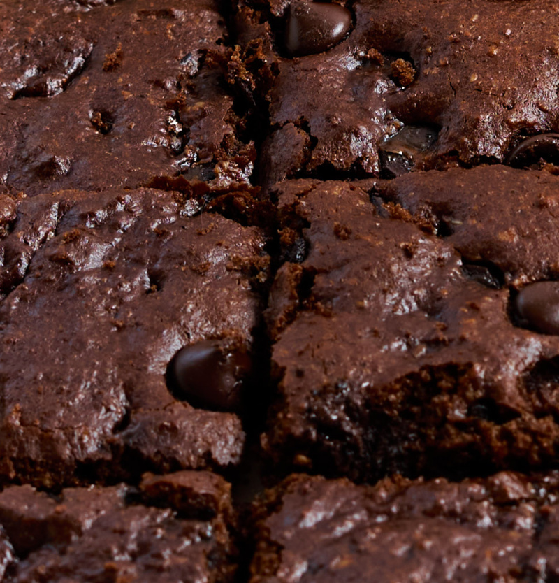 a close up of a tray of sliced chocolate chip almond butter bars
