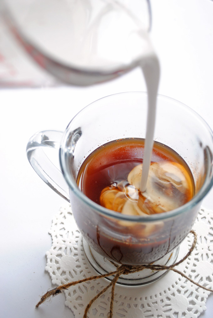 milk being poured into a cup of chai tea