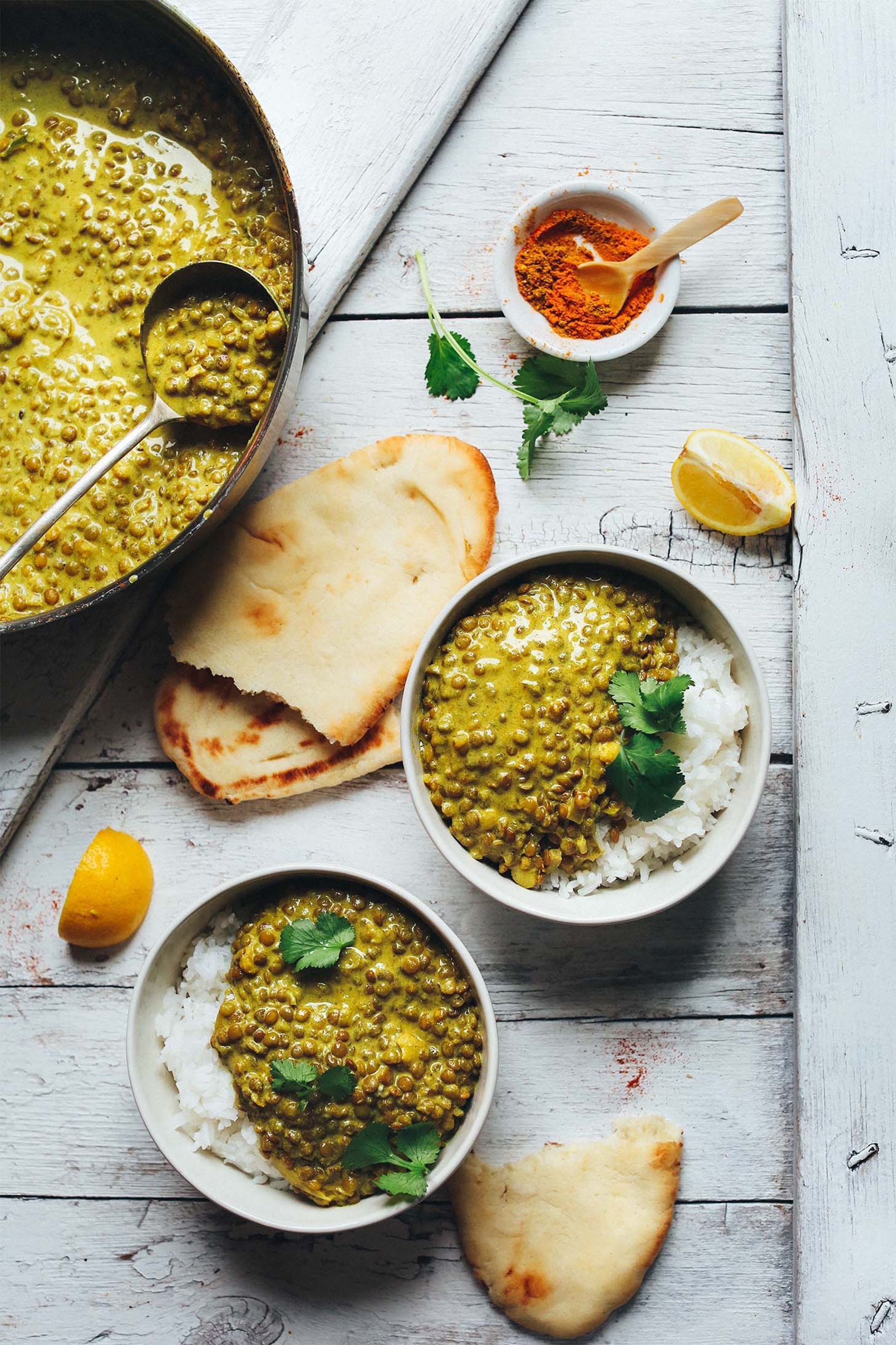 a batch of vegan green curry served with rice and flatbread