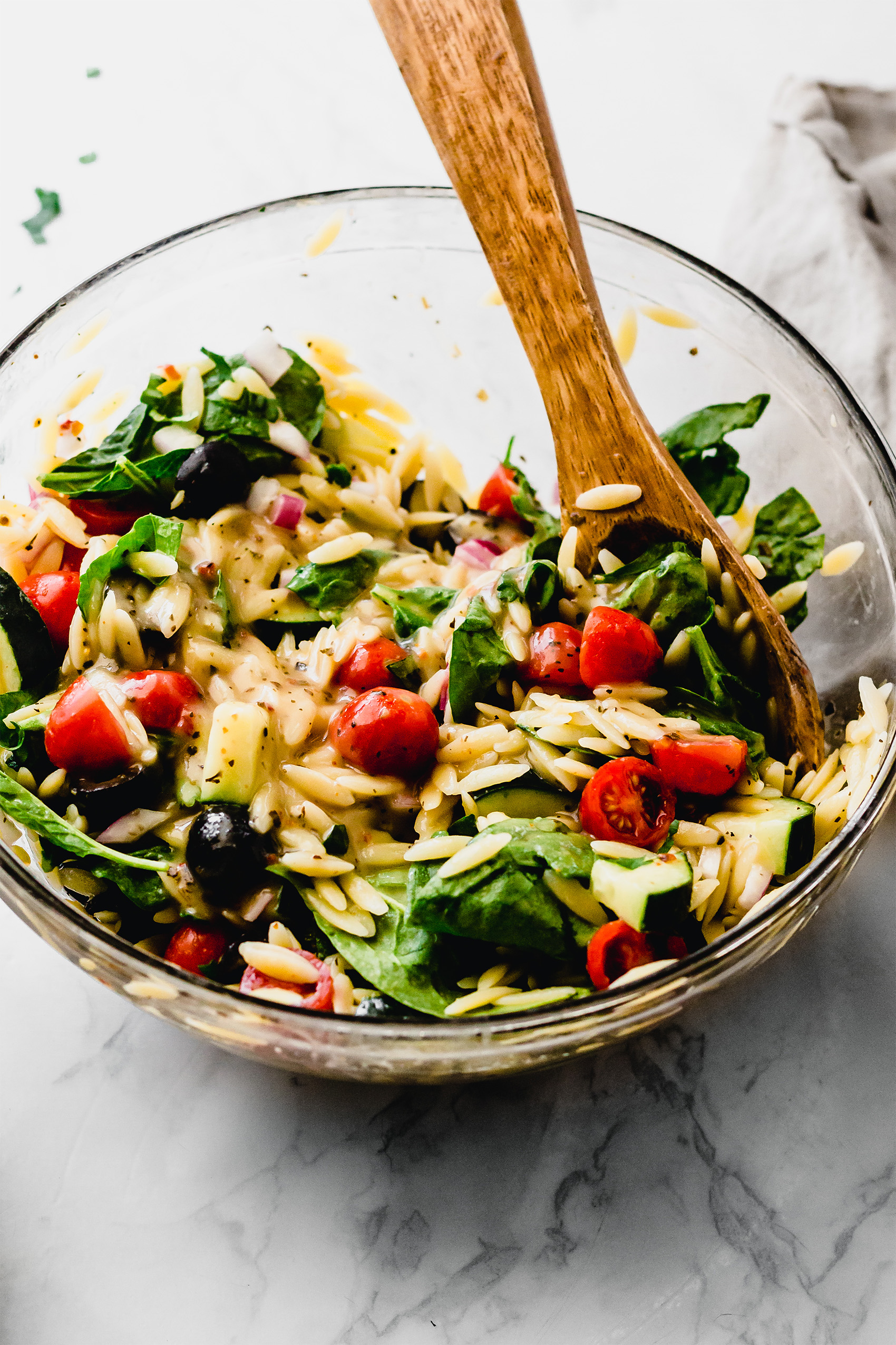 a large mixing bowl filled with a vegan caprese orzo salad