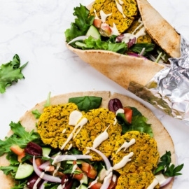two pitas filled with greens, falafel and tahini