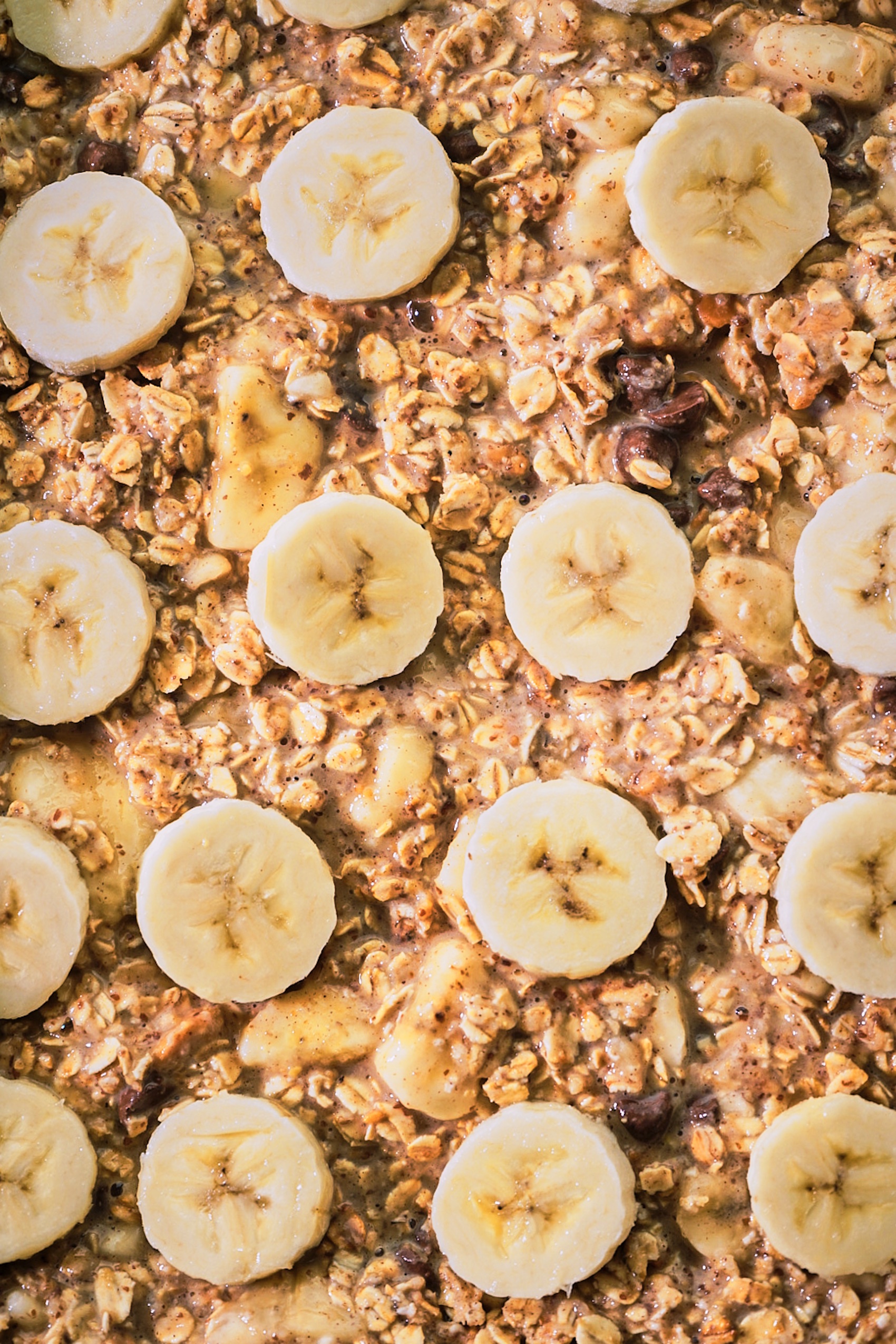 sliced bananas arranged on top of a dish of baked oatmeal