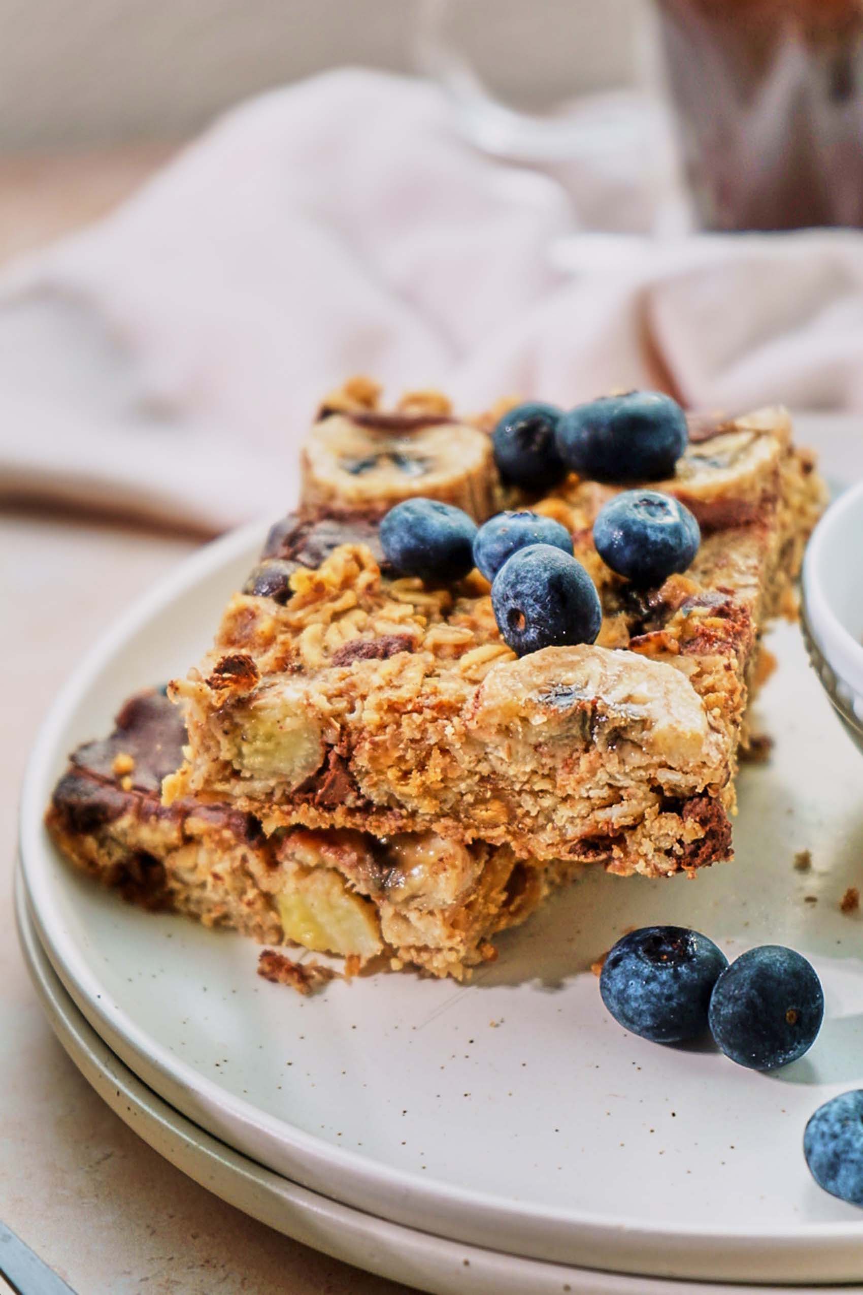 two slices of vegan baked oatmeal topped with blueberries