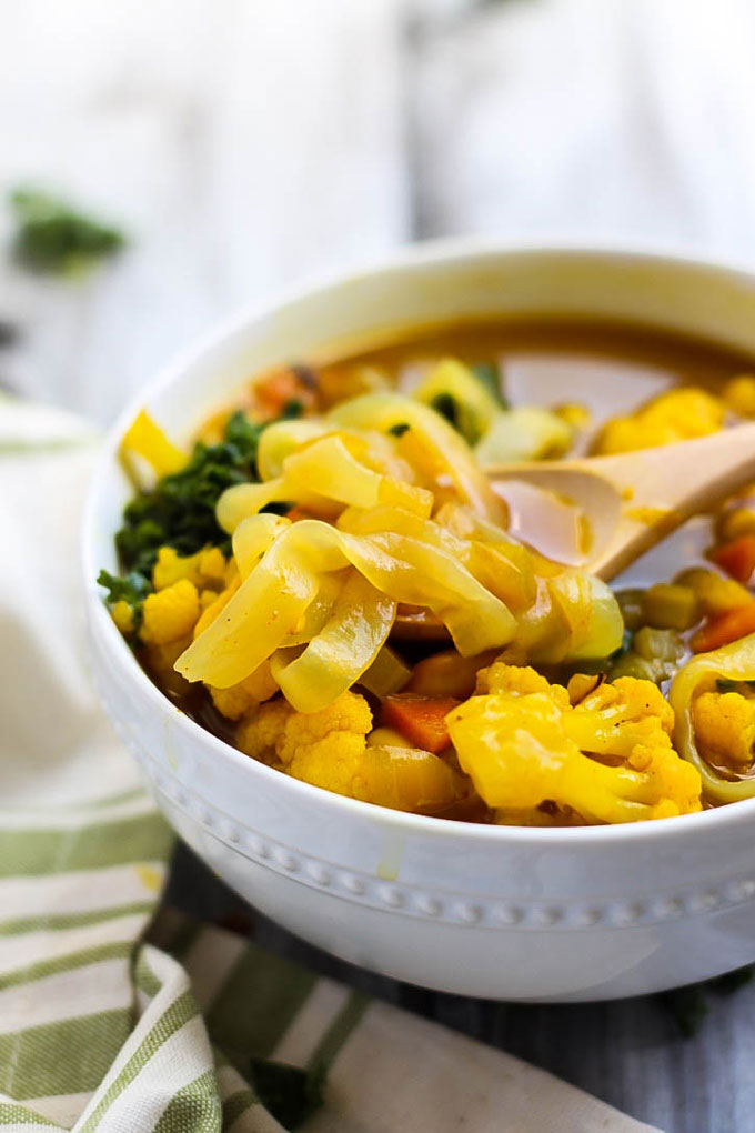 a bowl of turmeric soup with noodles