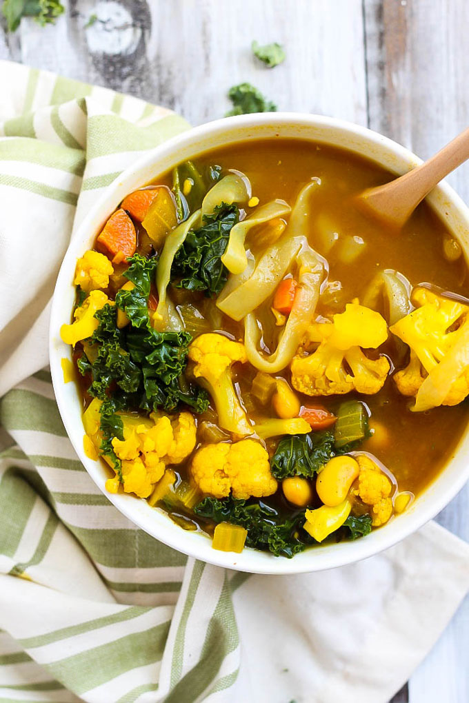 a bowl of turmeric soup with cauliflower and white beans