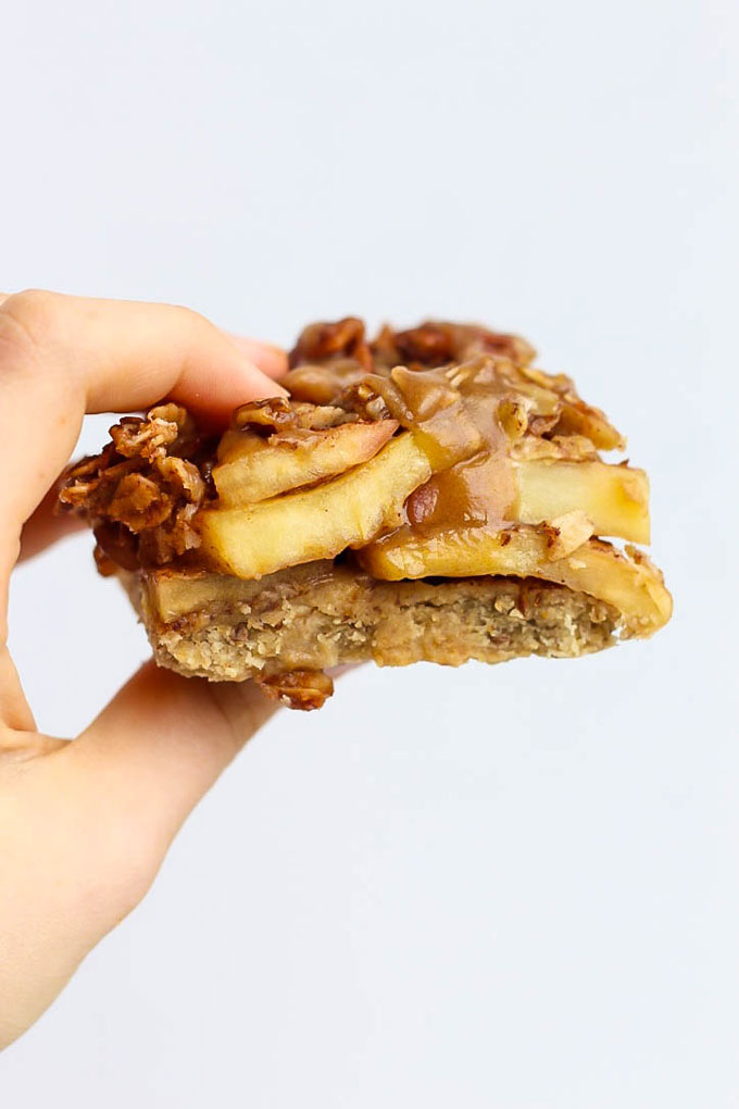 a hand holds a square apple pie bar