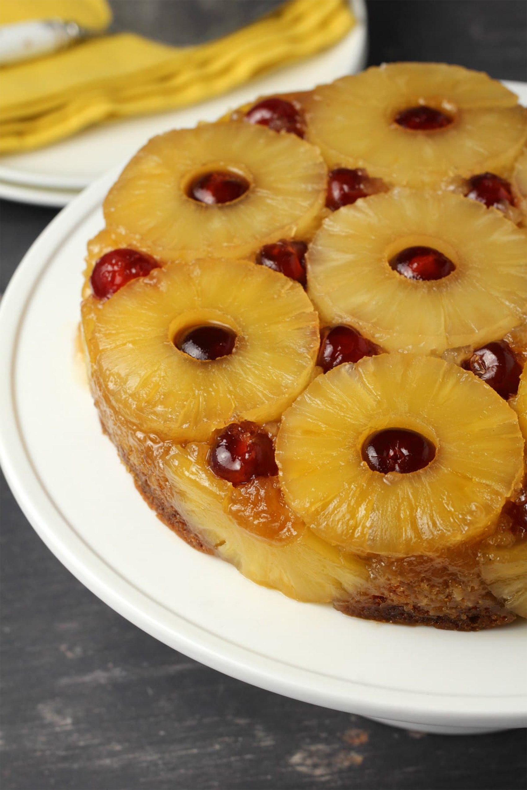 a pineapple upsidedown cake topped with pineapple rings and cherries