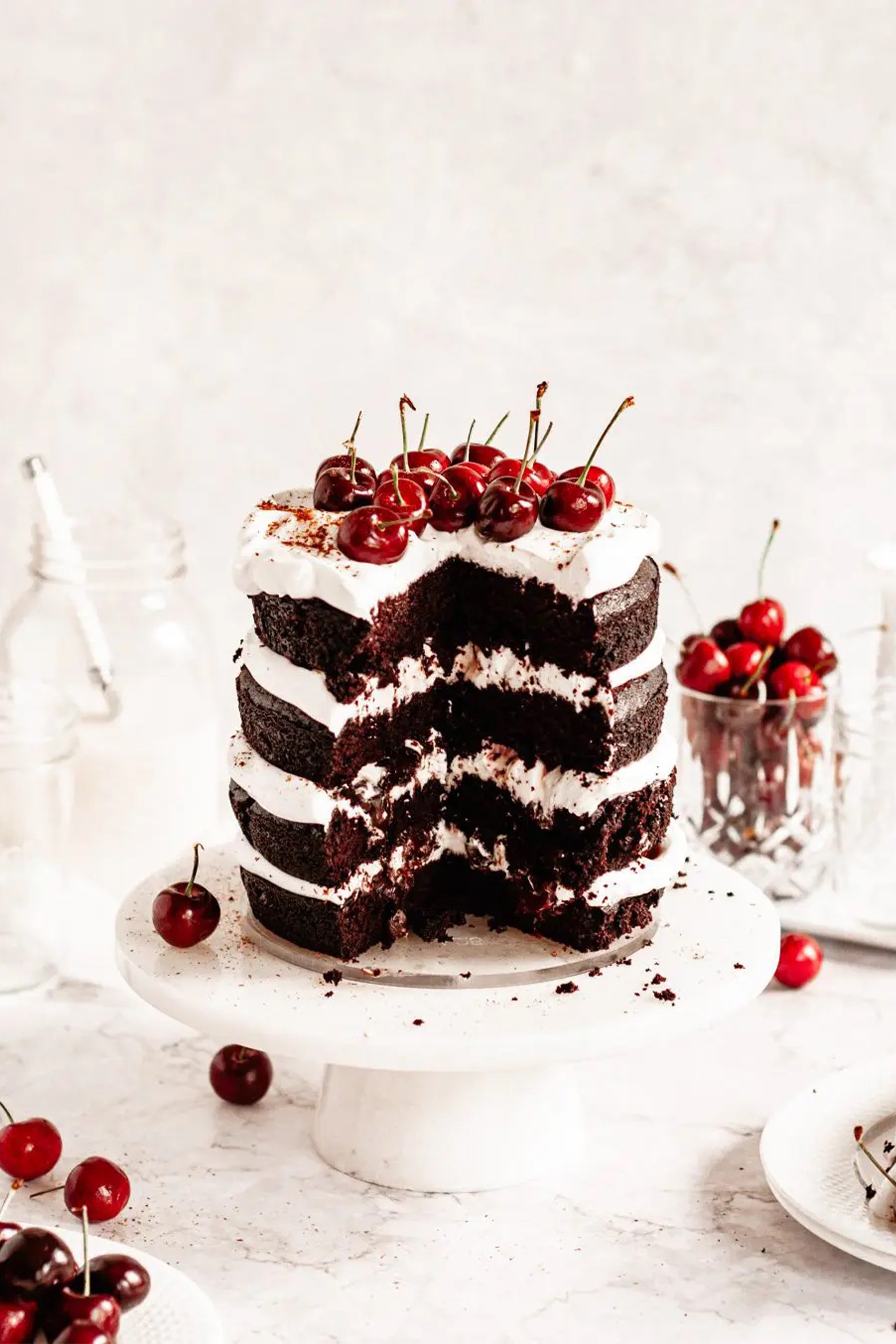 a vegan black forest cake topped with fresh cherries