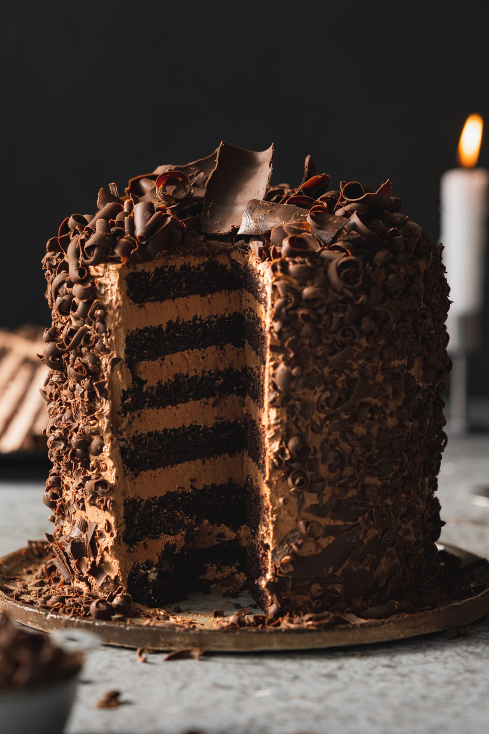 a vegan chocolate layer cake covered in chocolate shards