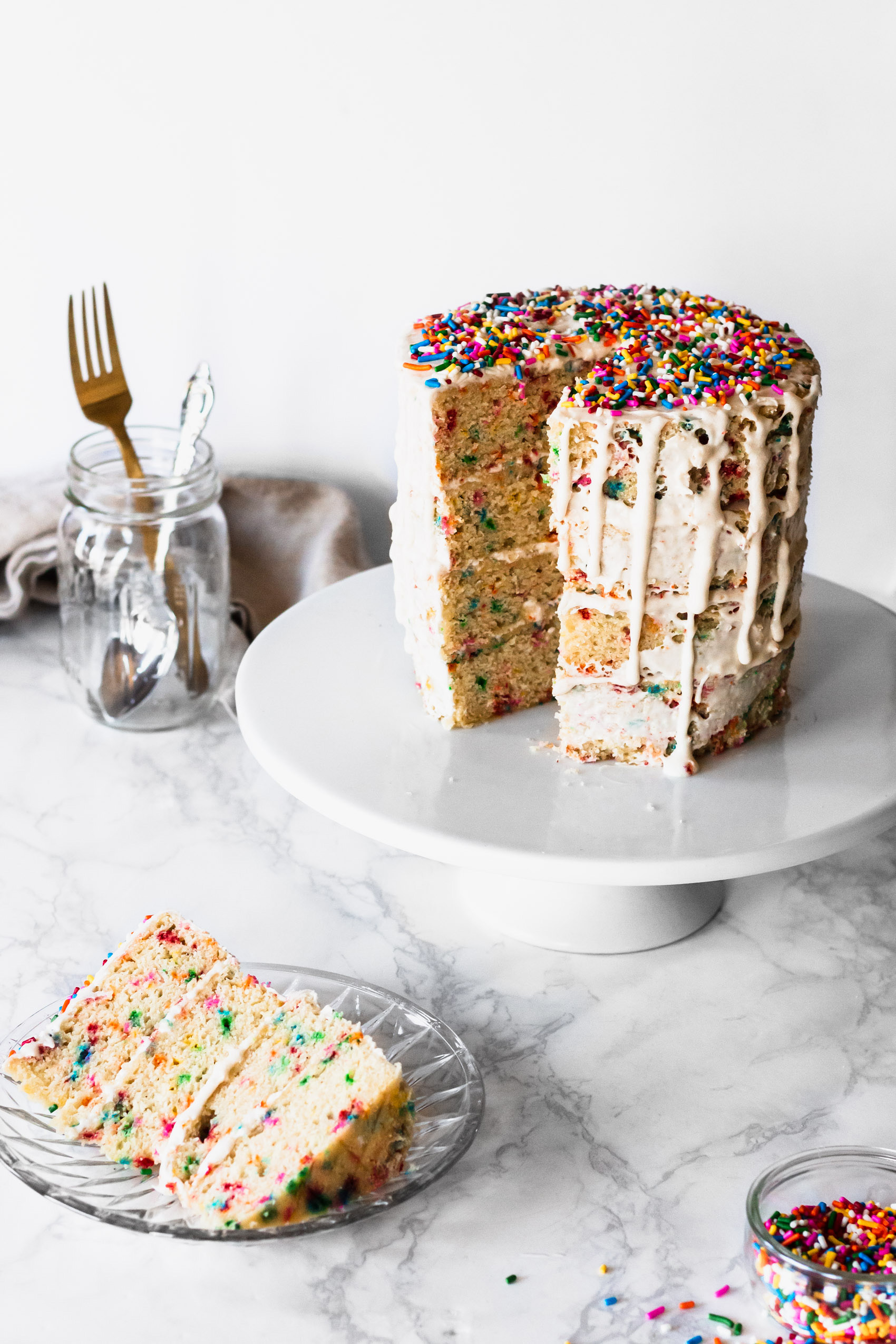 a vegan funfetti cake with a single slice served on a plate