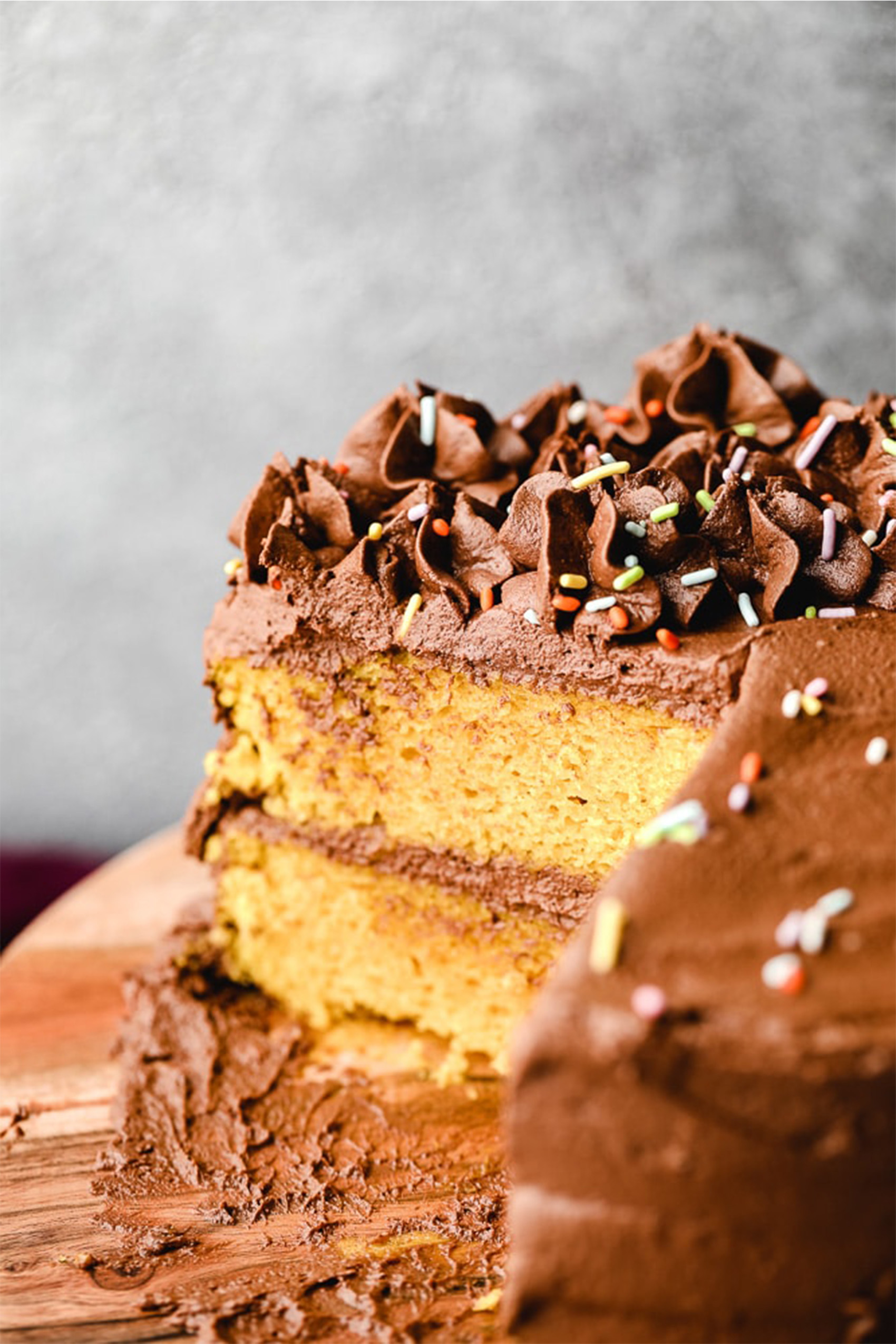 a vegan yellow cake topped with chocolate frosting