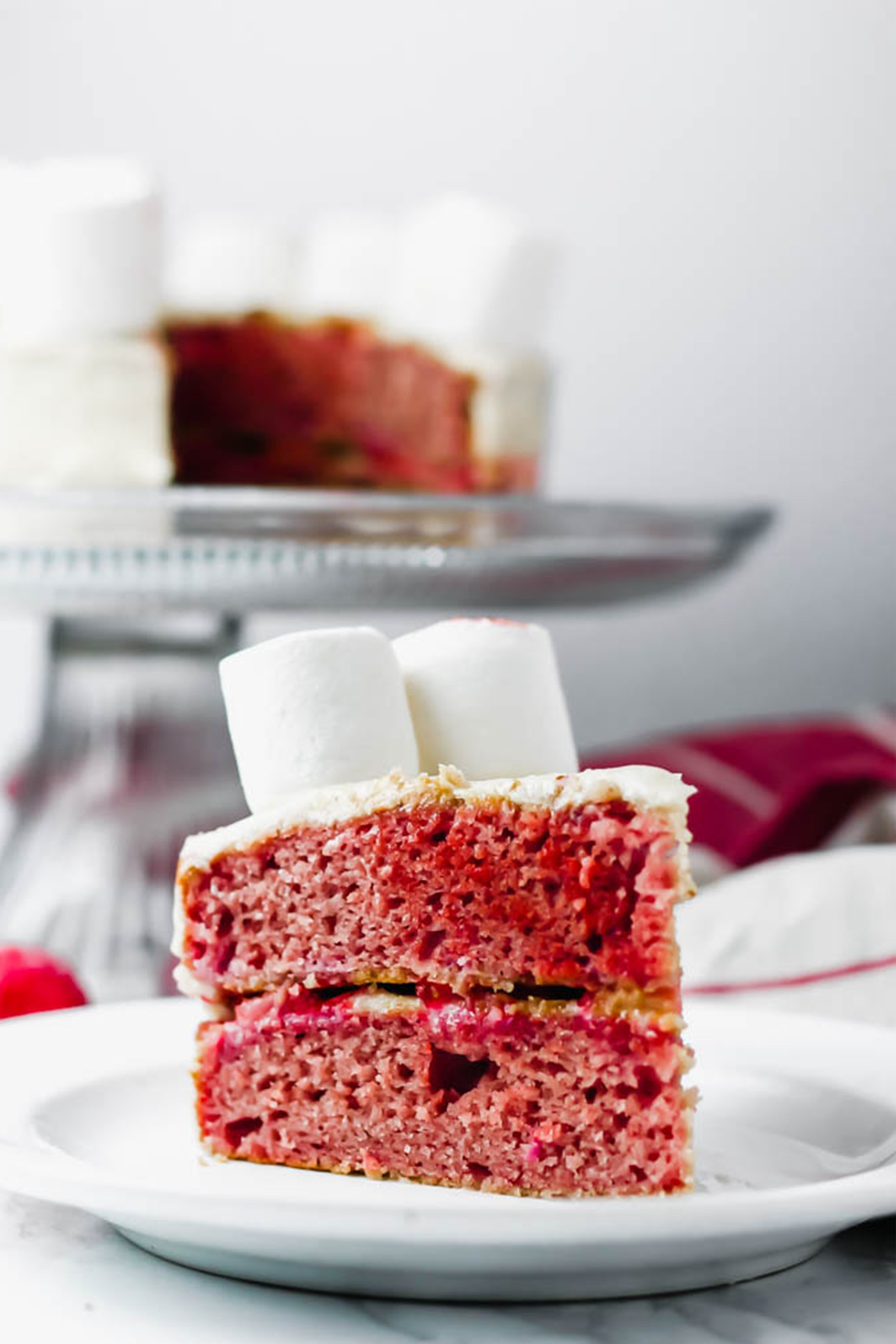 a slice of vegan strawberry cake topped with marshmallows