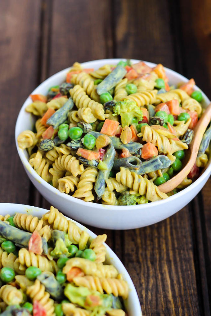 two bowls of vegan pasta salad with veggies and a curried tofu sauce