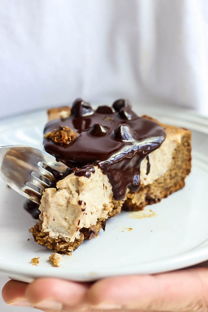 a slice of vegan cheesecake covered in chocolate sauce