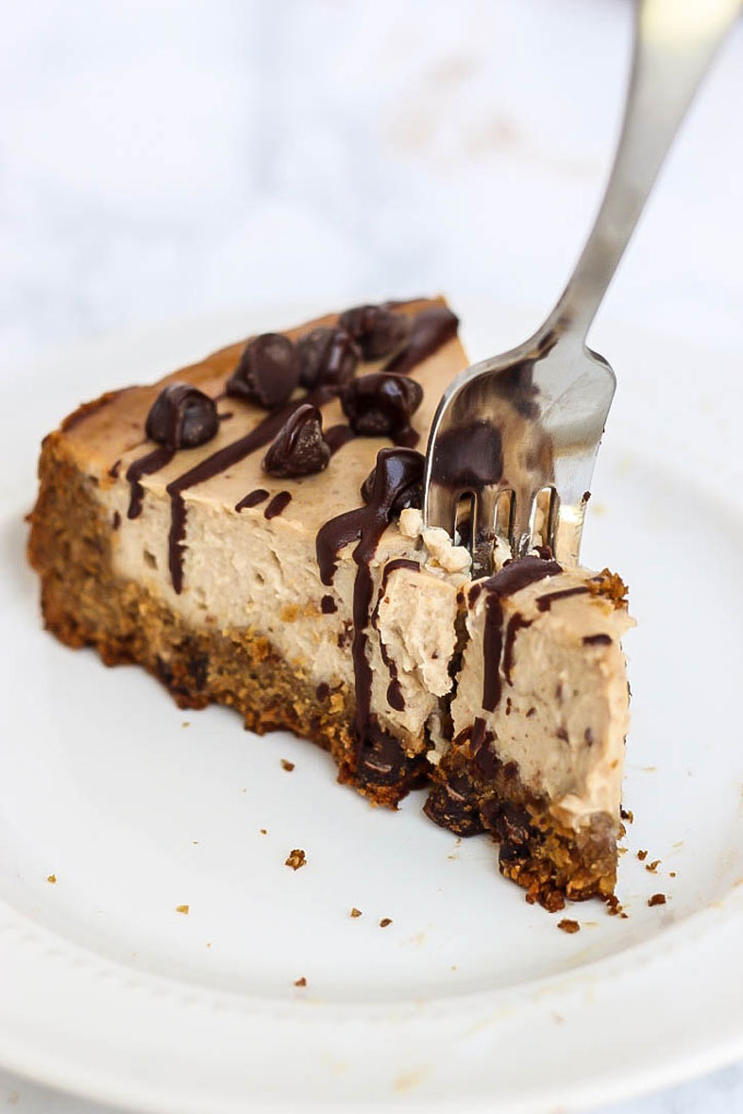 a fork digging into the tip of a slice of chocolate chip cheesecake