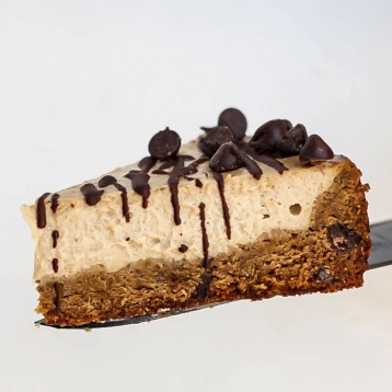 a spatula serving a slice of chocolate chip cookie cheesecake