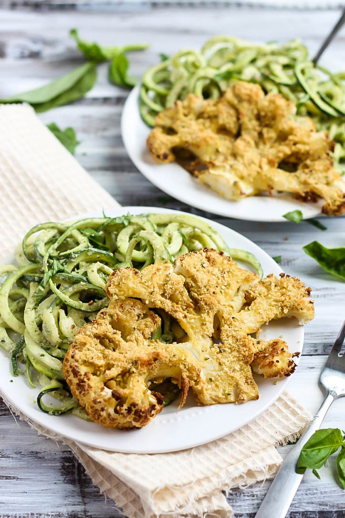 These Vegan Parmesan Cauliflower Steaks over Hemp Pesto Zoodles feel gourmet but are done in 1 hour! This gluten-free dinner is perfect to impress anyone.