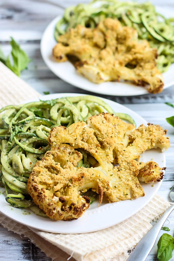 These Vegan Parmesan Cauliflower Steaks over Hemp Pesto Zoodles feel gourmet but are done in 1 hour! This gluten-free dinner is perfect to impress anyone.