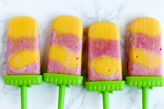 Satisfy your sweet tooth with these healthier Vegan Strawberry Orange Mango Popsicles! Only a few ingredients for a delicious treat that will cool you off.