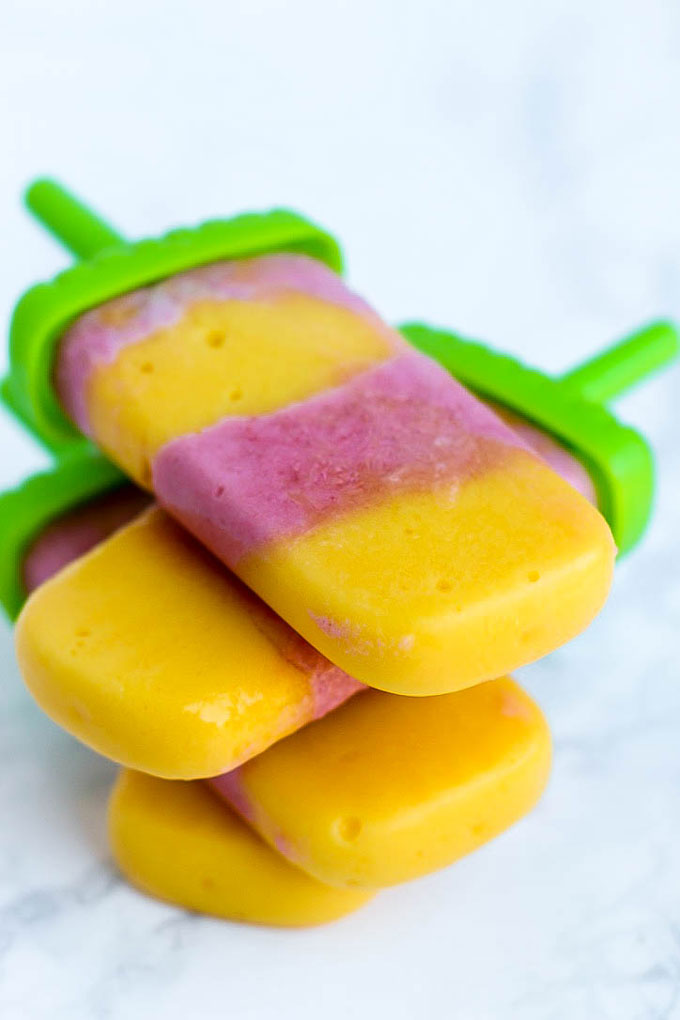 Satisfy your sweet tooth with these healthier Vegan Strawberry Orange Mango Popsicles! Only a few ingredients for a delicious treat that will cool you off.