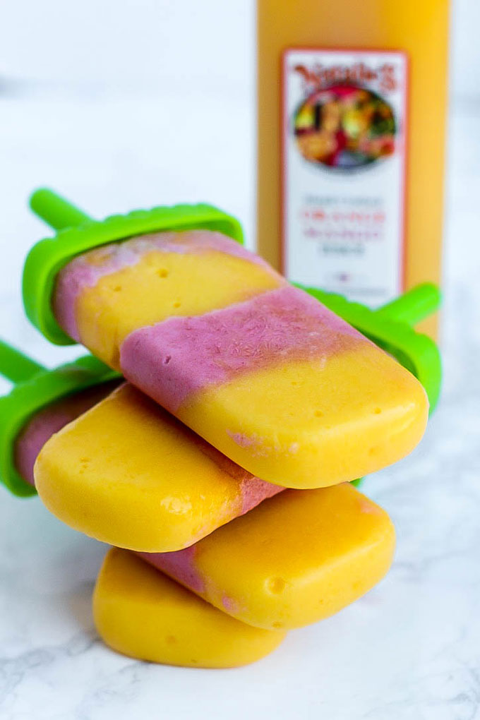 Satisfy your sweet tooth with these healthier Vegan Strawberry Orange Mango Popsicles! Only a few ingredients for a delicious treat that will cool you off.