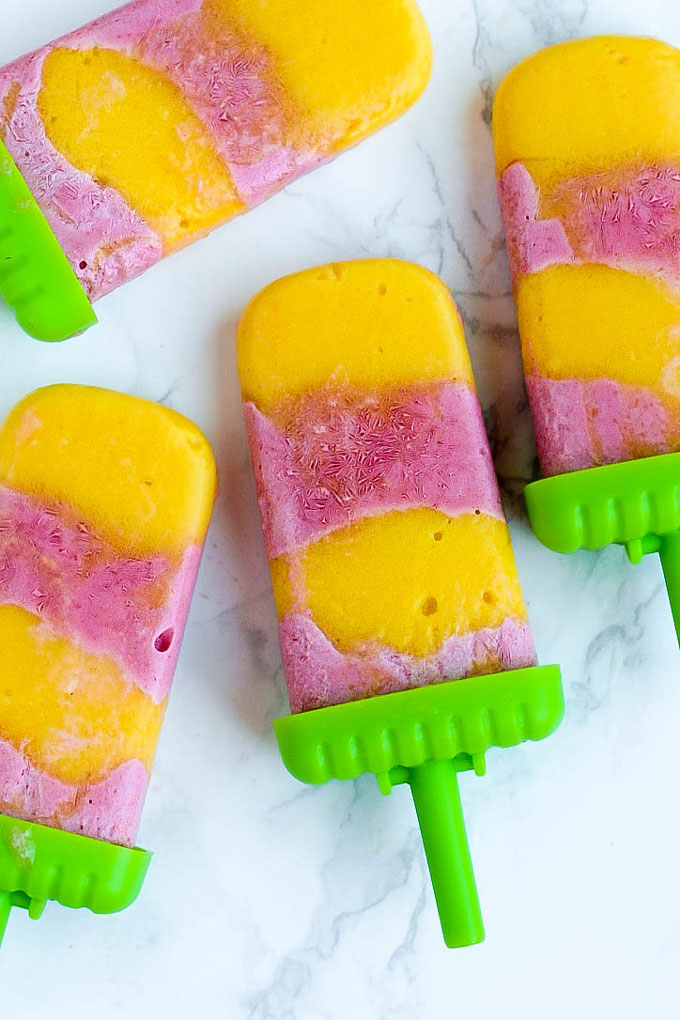 Satisfy your sweet tooth with these healthier Vegan Strawberry Orange Mango Popsicles! Only a few ingredients for a delicious treat that will cool you off.