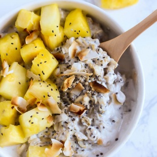 a bowl of pineapple oatmeal topped with toasted coconut