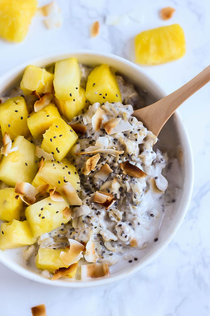 a bowl of pineapple oatmeal topped with toasted coconut