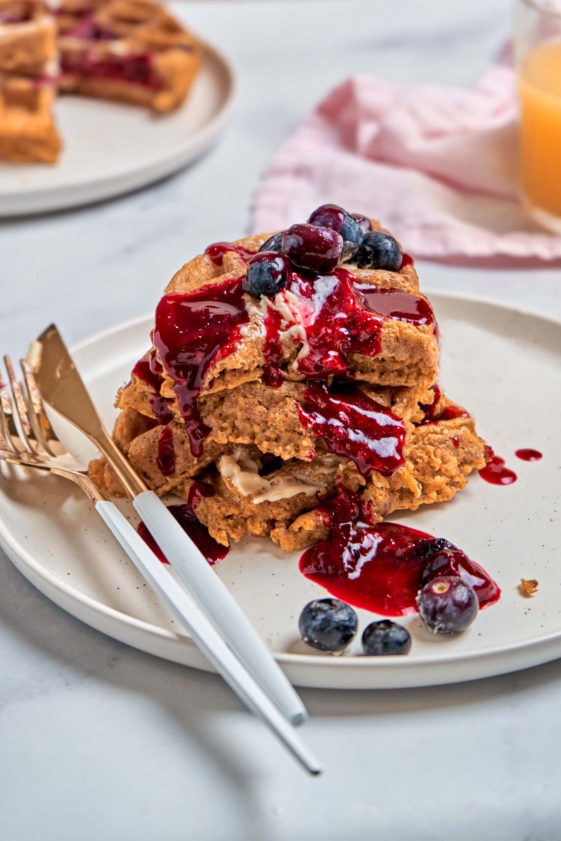 a plate of vegan waffles topped with blueberry sauce