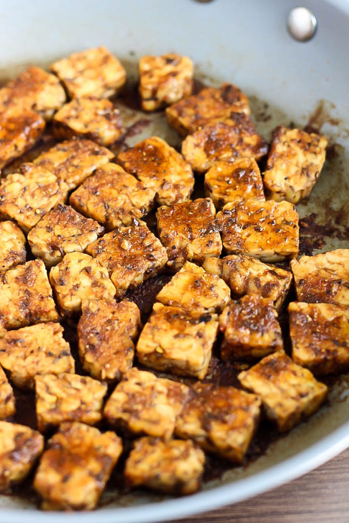 tempeh cooks in a skillet with a smoky vegan marinade