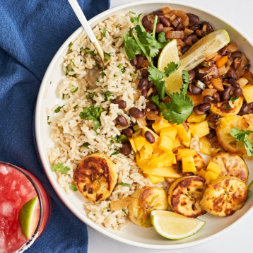 a bowl with cilantro lime rice, black beans, mango and fried plantains