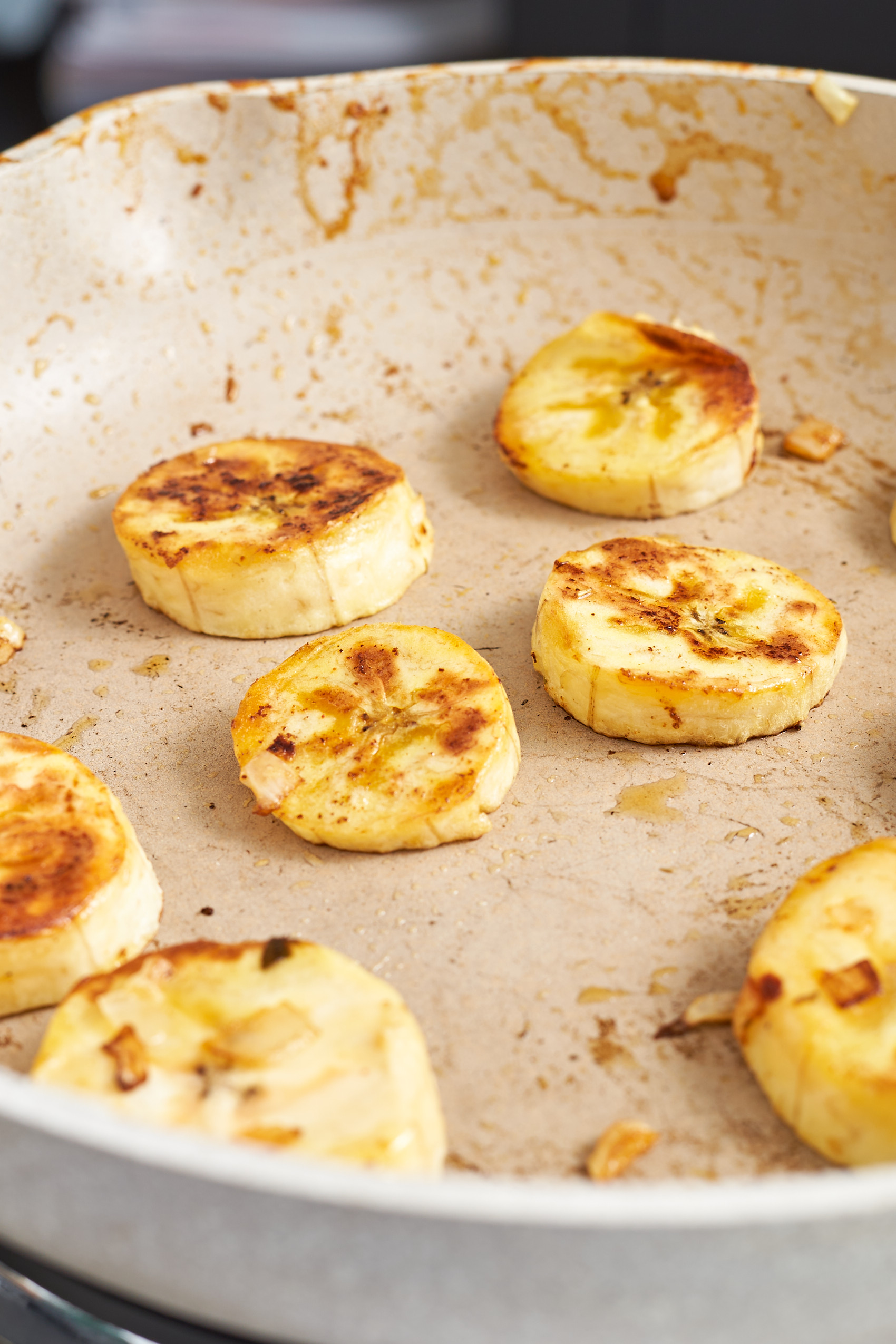 a close up of a skillet with fried plantain slices