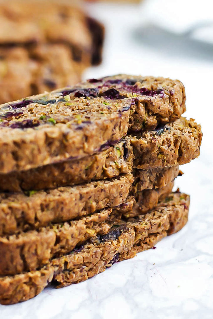 Five slices of blueberry zucchini bread stacked on top of one another