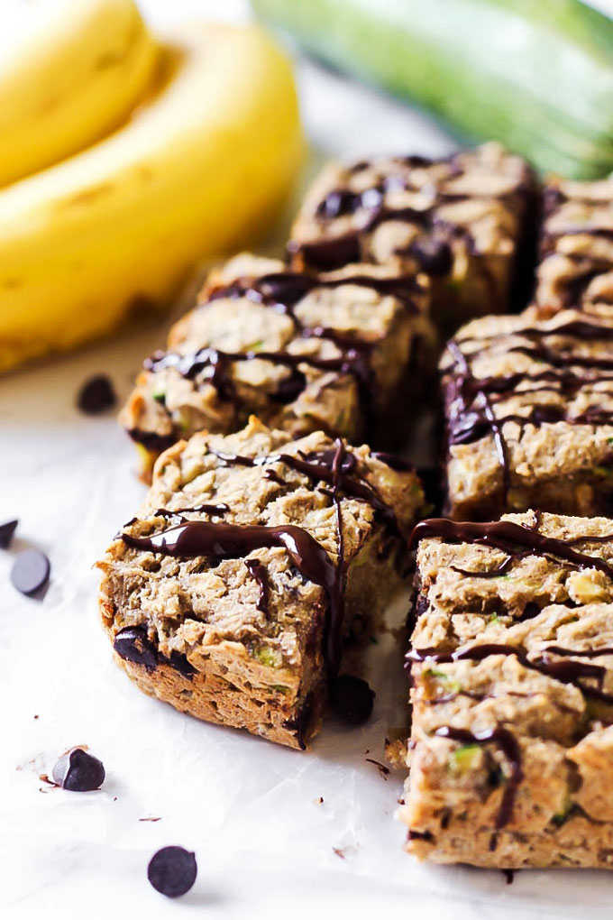 a batch of sliced breakfast bars served next to a bunch of bananas