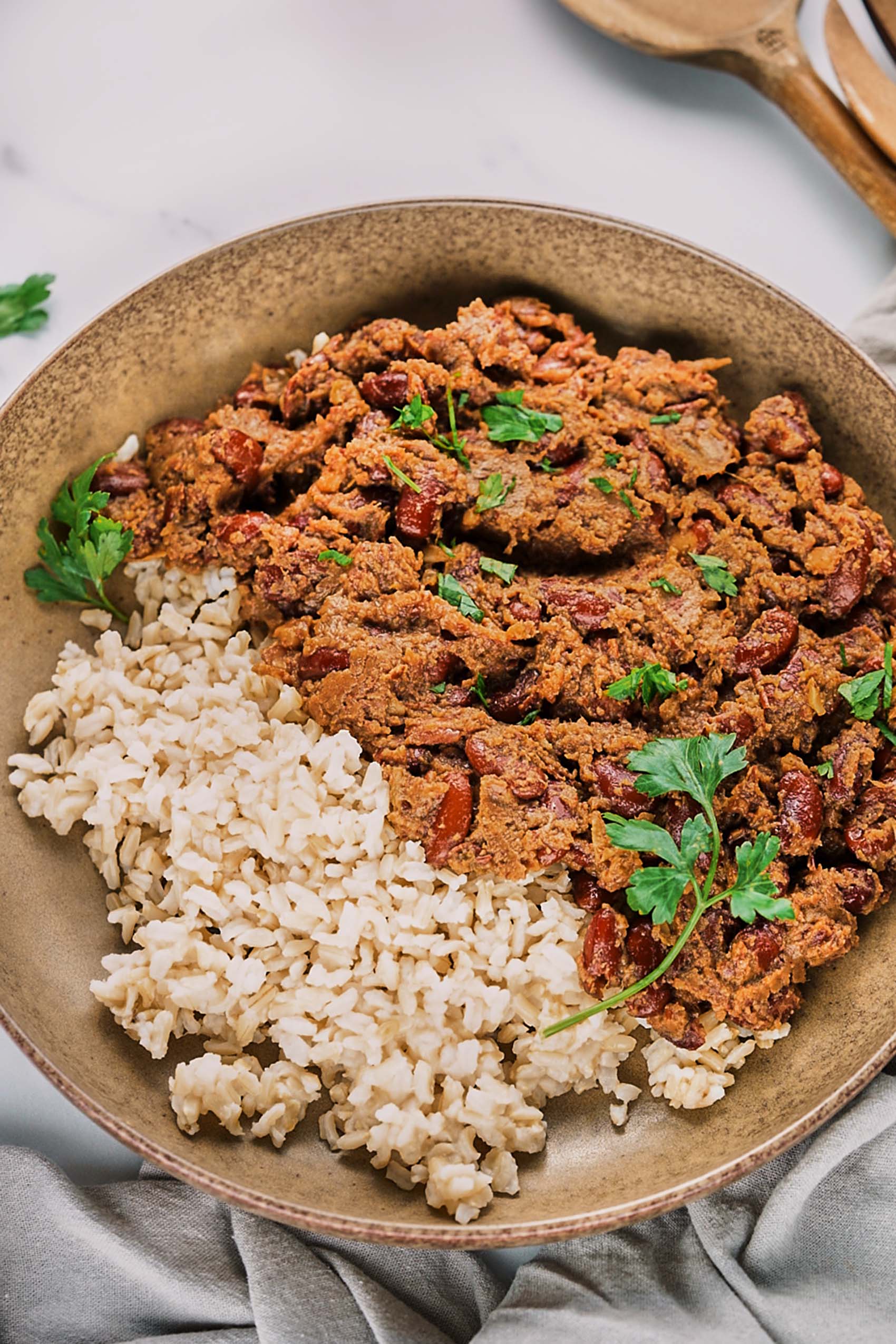 a bowl of red beans and rice topped with fresh parsley