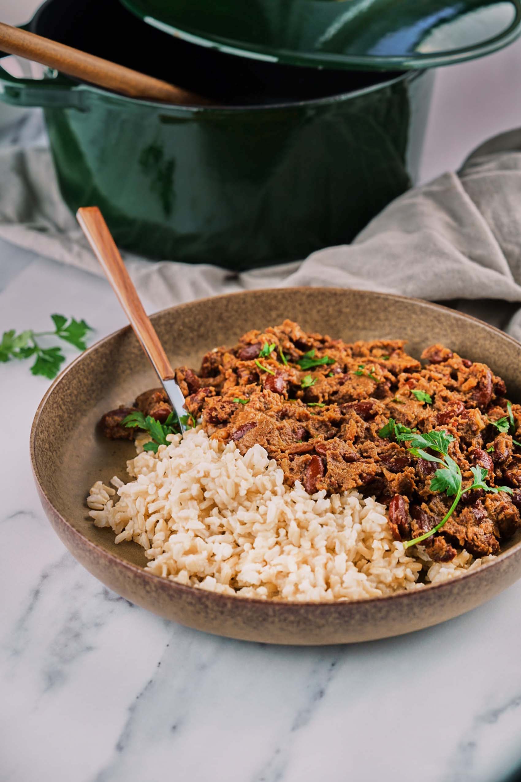 a bowl of vegan red beans and rice next to a pot