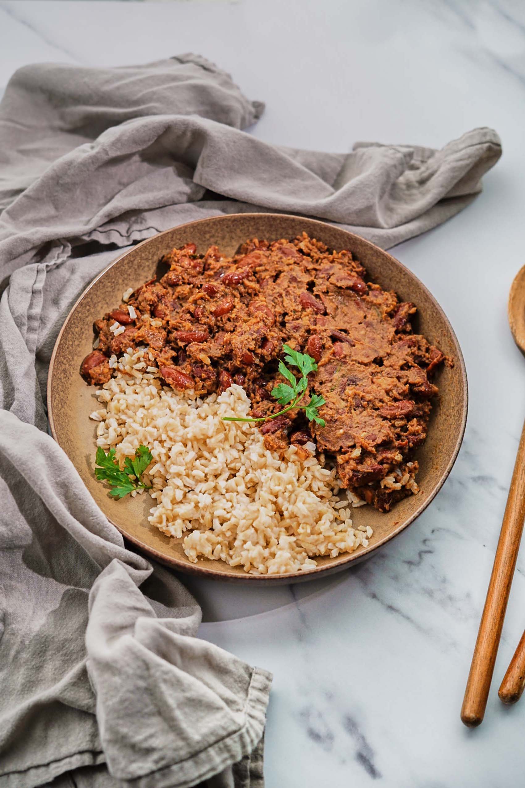 a bowl filled with brown rice and cajun style red beans