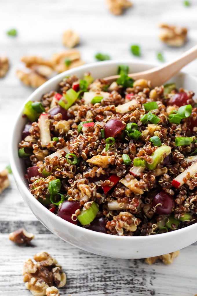 A quinoa salad containing radishes, grapes, walnuts, green onion and a curry dressing