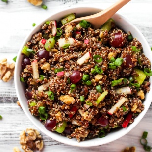 a bowl of quinoa salad with grapes, walnuts, radishes, green onions, celery and a curry vinaigrette