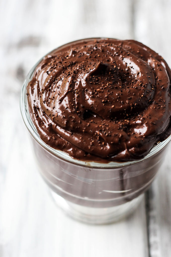 a cup of vegan chocolate pudding topped with chocolate shavings