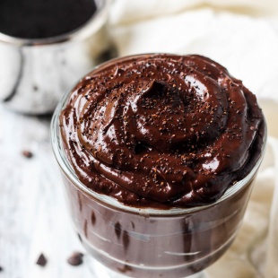 a cup of vegan chocolate pudding topped with chocolate shavings