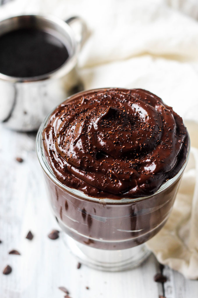 a cup of vegan chocolate pudding topped with chocolate shavings