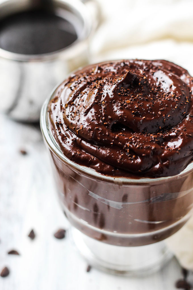 a bowl of avocado chocolate pudding topped with chocolate shavings