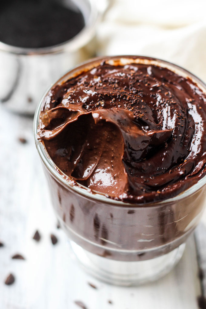 a bowl of chocolate pudding with a scoop taken out to reveal the creamy texture