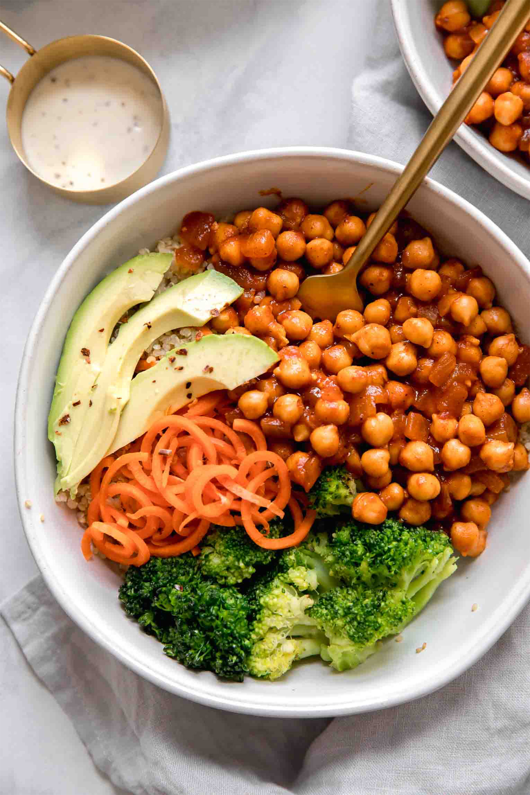 a chickpea bowl with avocado, spiralized carrots and broccoli