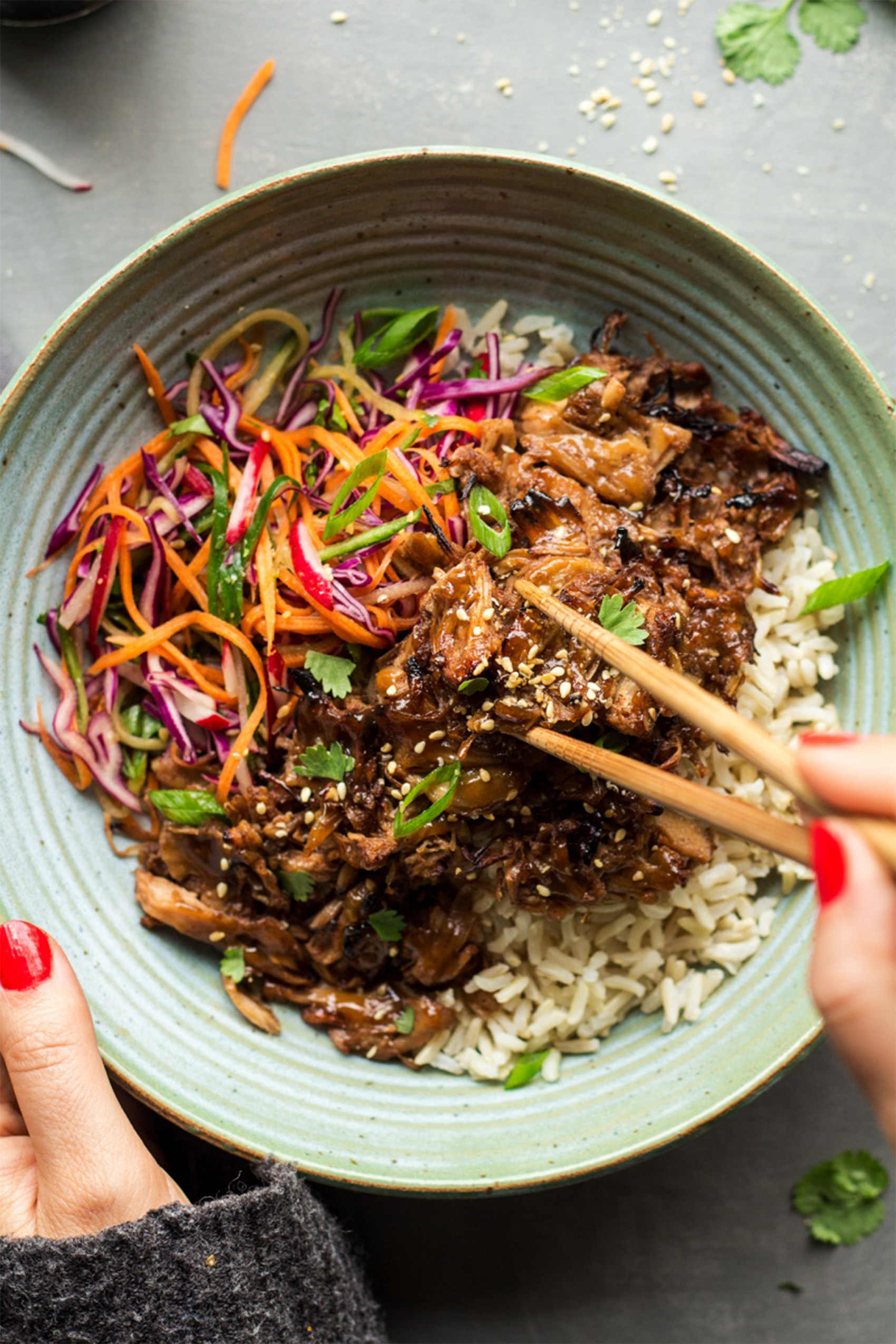 a pulled jackfruit bowl with shredded carrots over rice